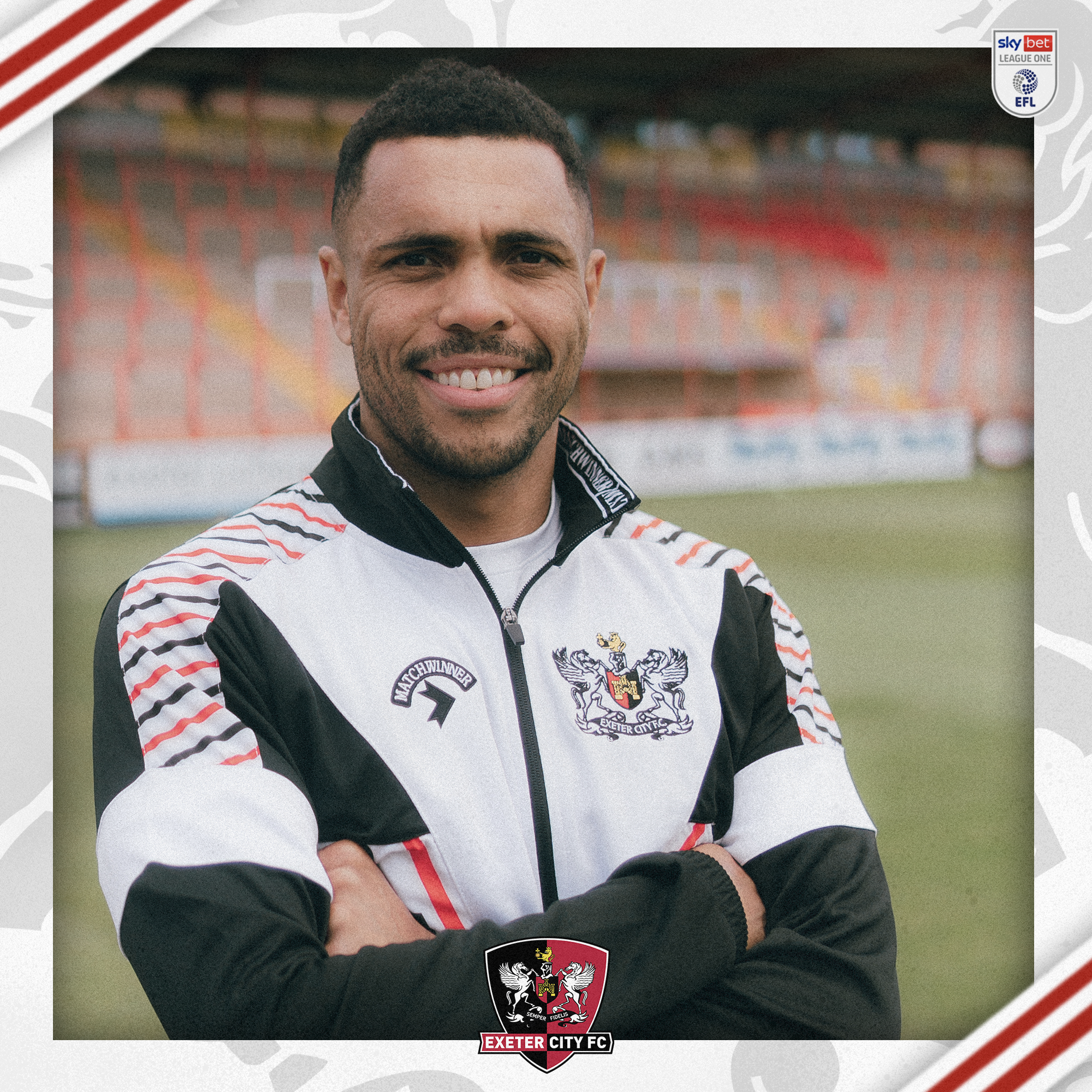 Josh Magennis with his arms folded wearing a retro Exeter City jacket