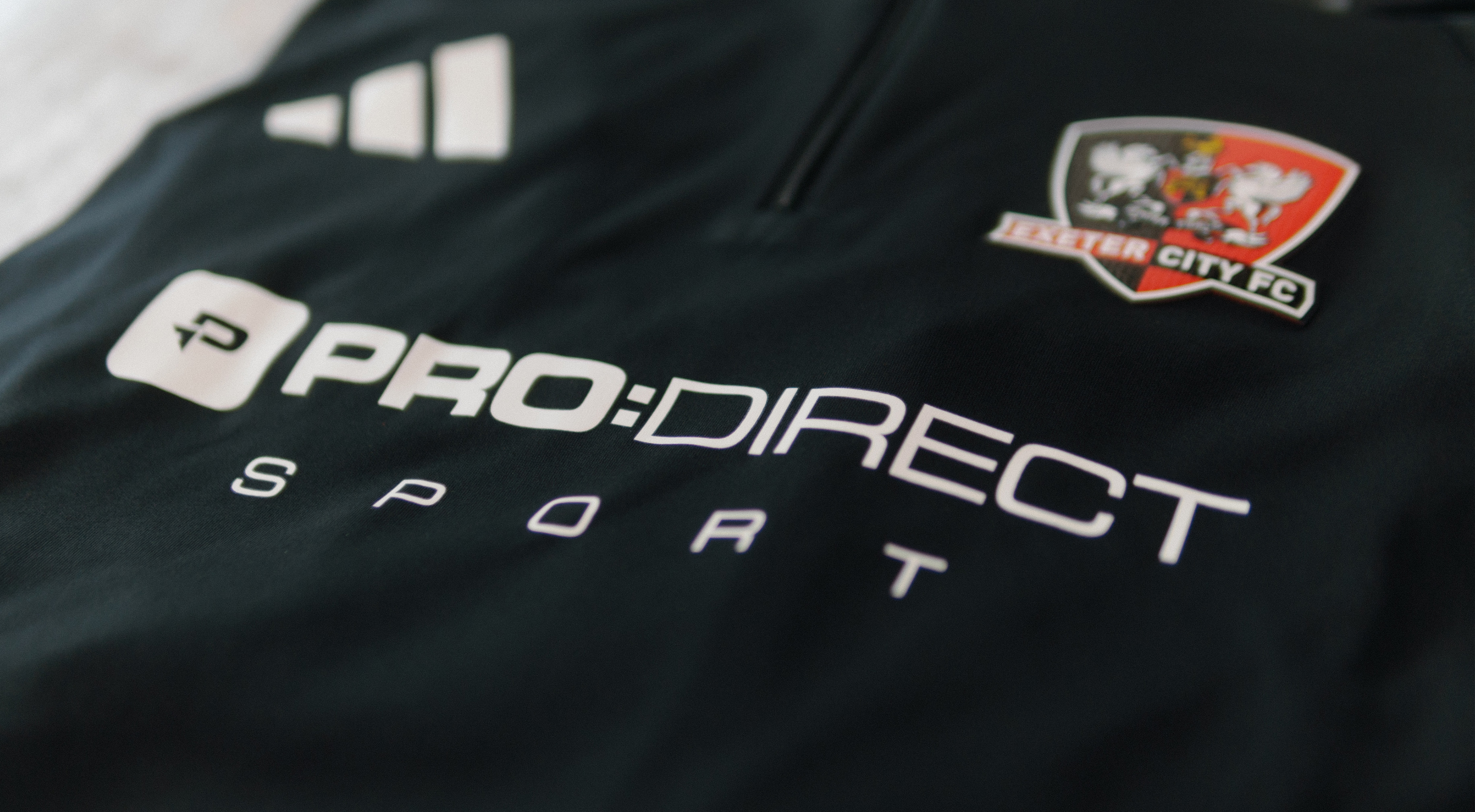 The image shows the Pro:Direct logo on an Exeter City training top