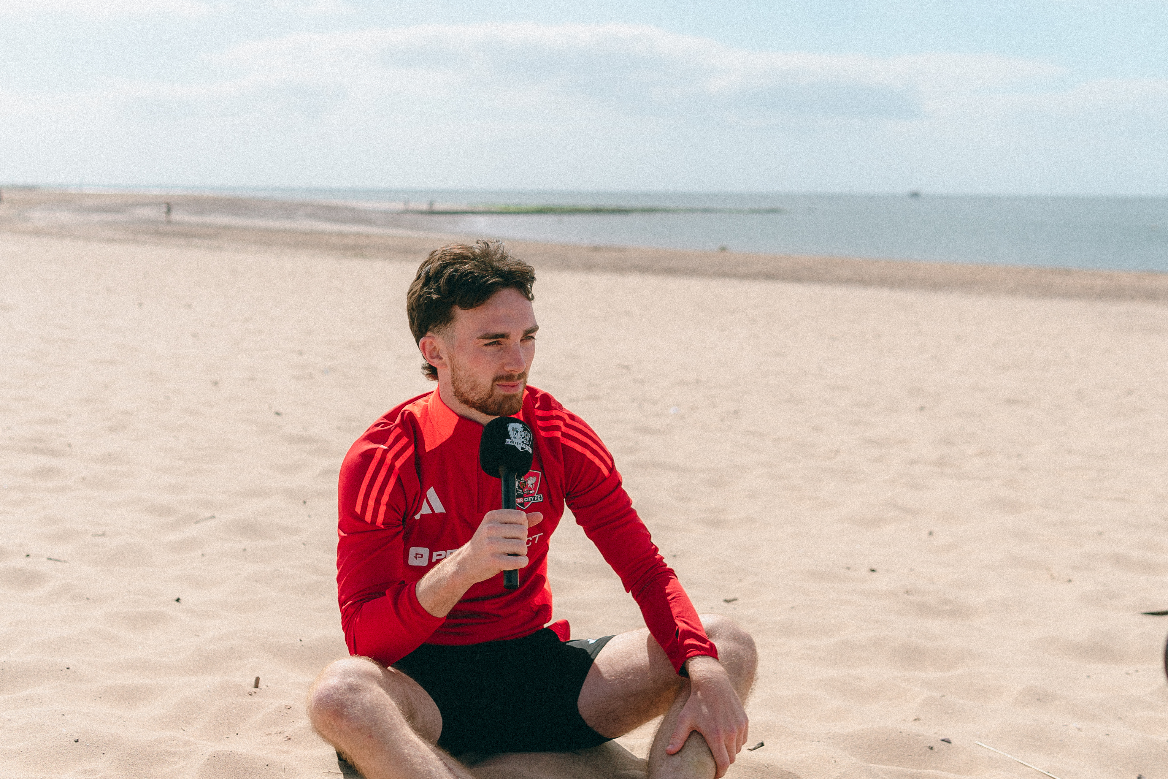 Ed Francis sat on the beach, speaking into a microphone