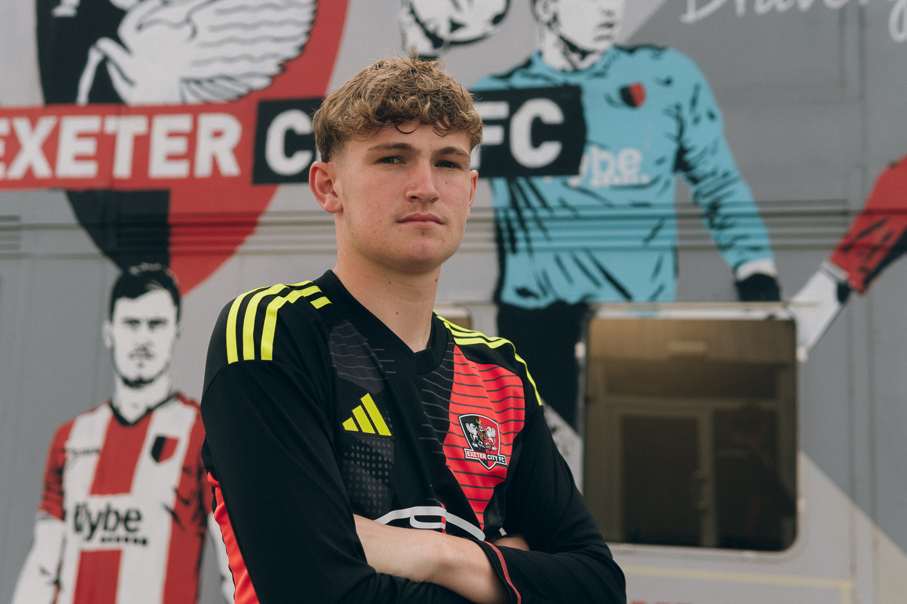 Frankie Phillips standing in front of the ECFC Academy building