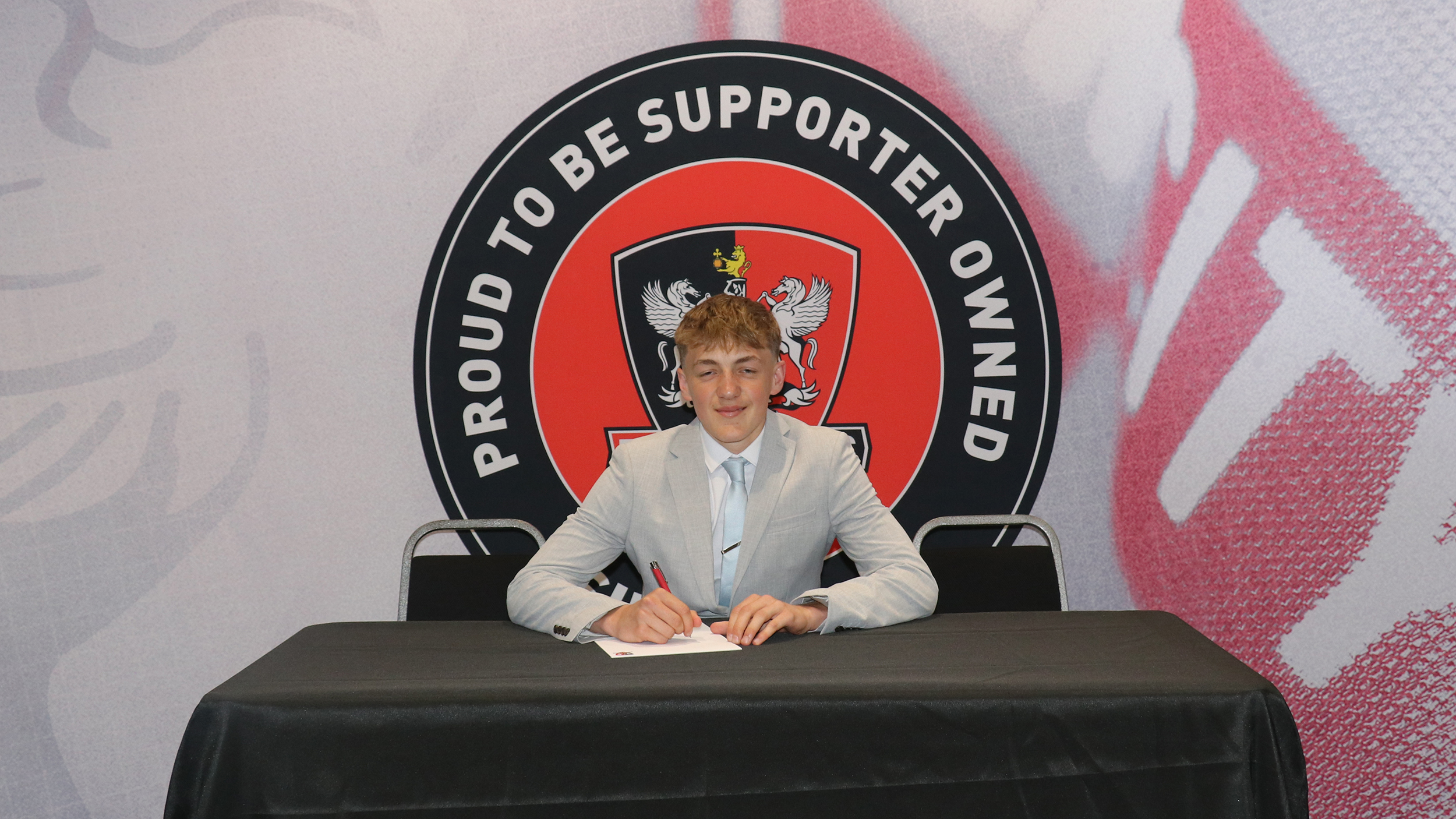 Image of Liam Cartwright signing his scholarship