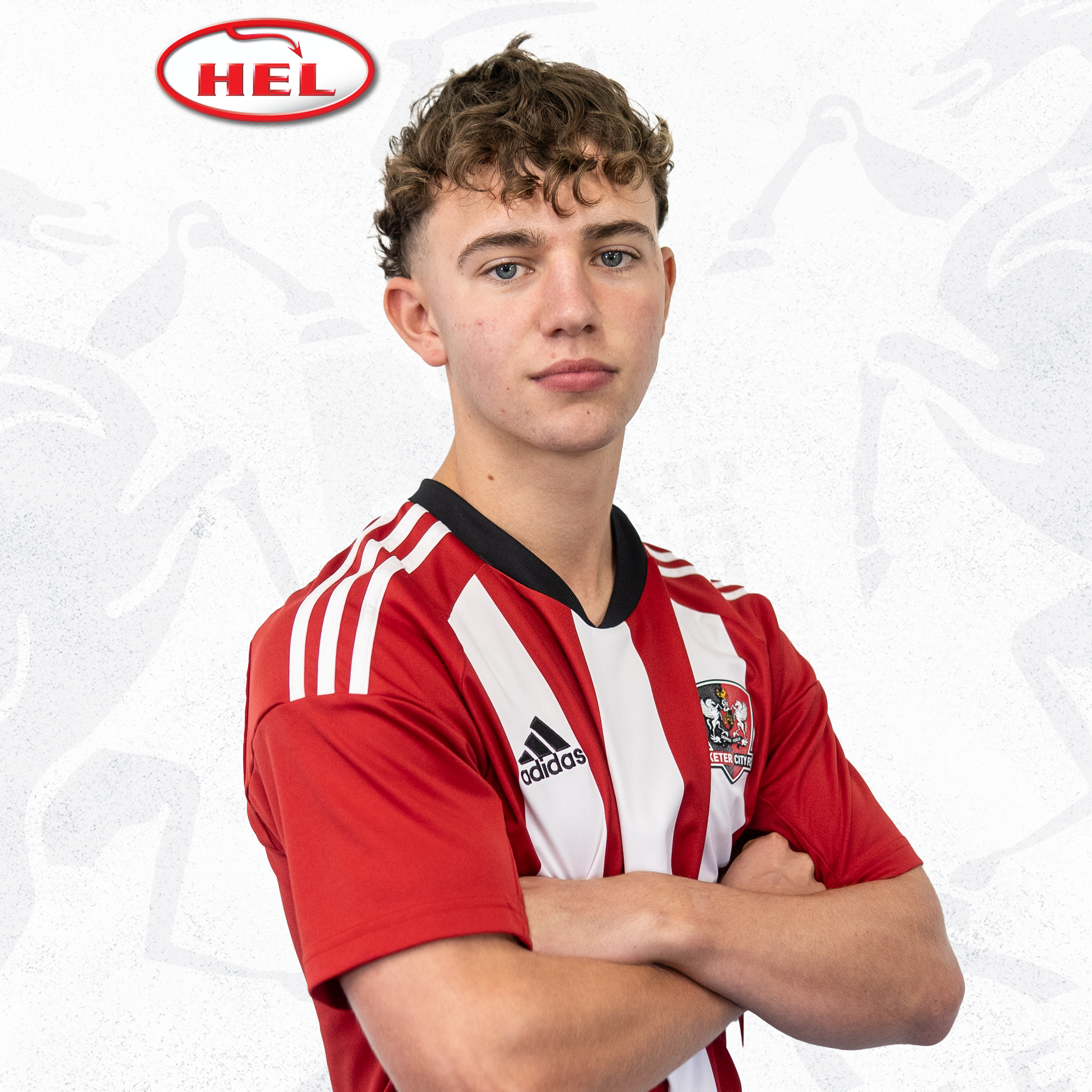 Jacca Cavendish, wearing a red and white home shirt, with his arms folded facing side on. The red and white HEL logo is in the corner of the image.