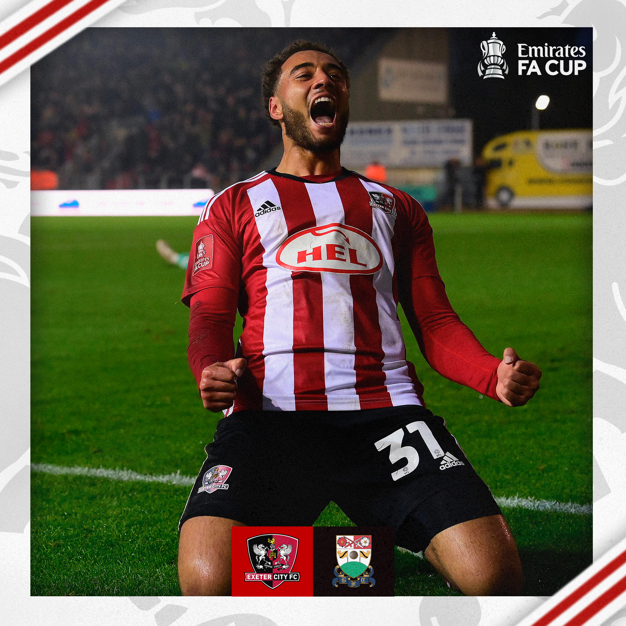 Jay Bird, in his red and white home kit, celebrating his goal by knee sliding in front of the big bank