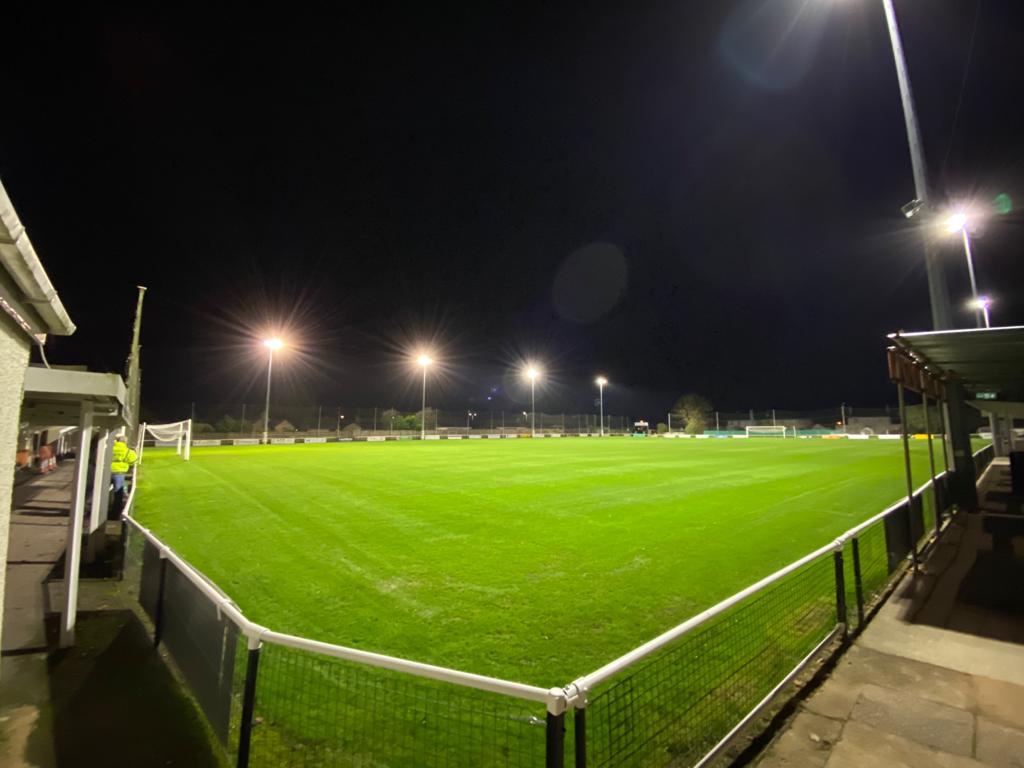 Image of the pitch, at night but illuminated by floodlights, at Willand Rovers' Silver Street ground.