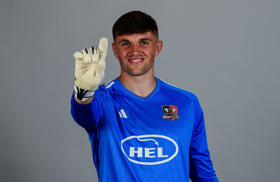 Exeter City goalkeeper Harry Lee points his glove to the sky