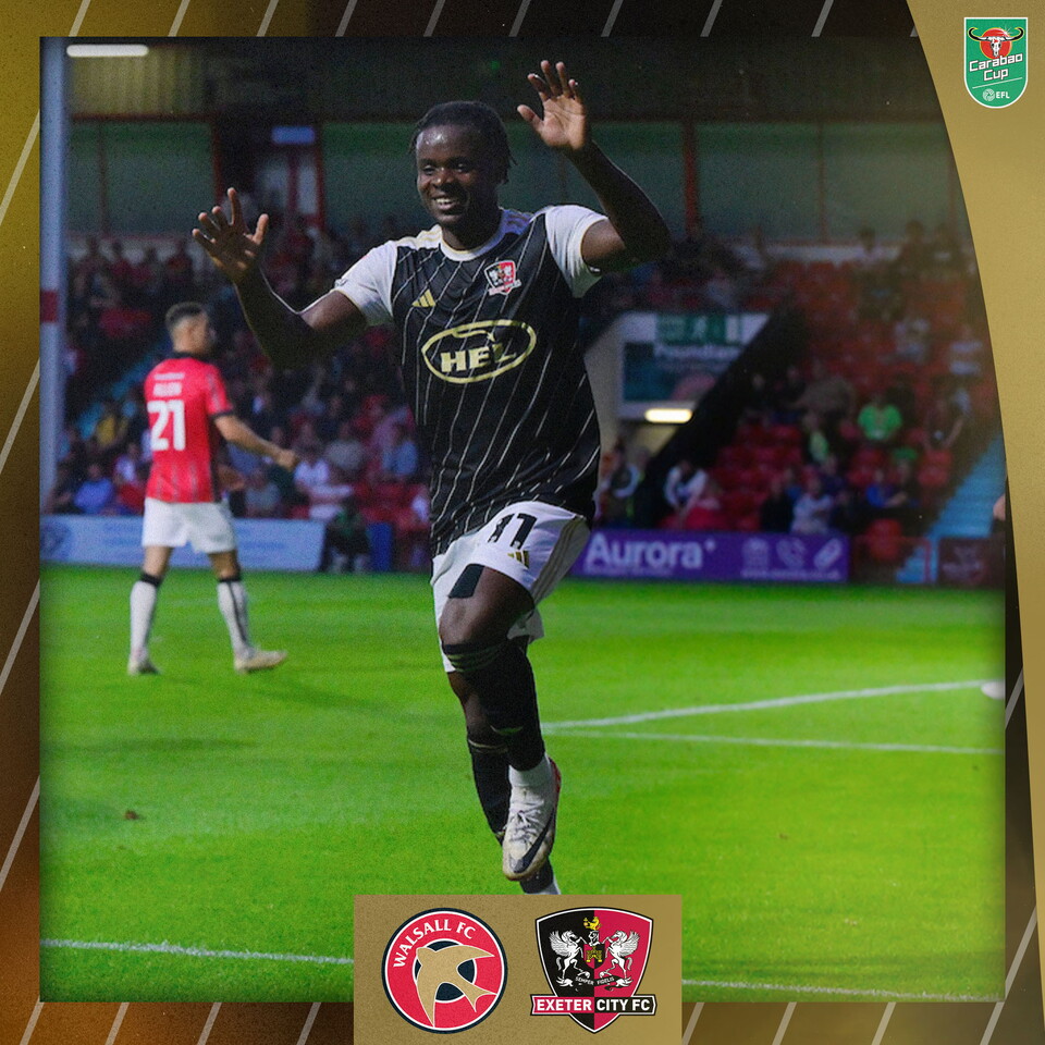 Millenic Allí, in Exeter City's black third kit, with white sleeves and a gold trim, about to jump into a cartwheel to celebrate his opening goal.