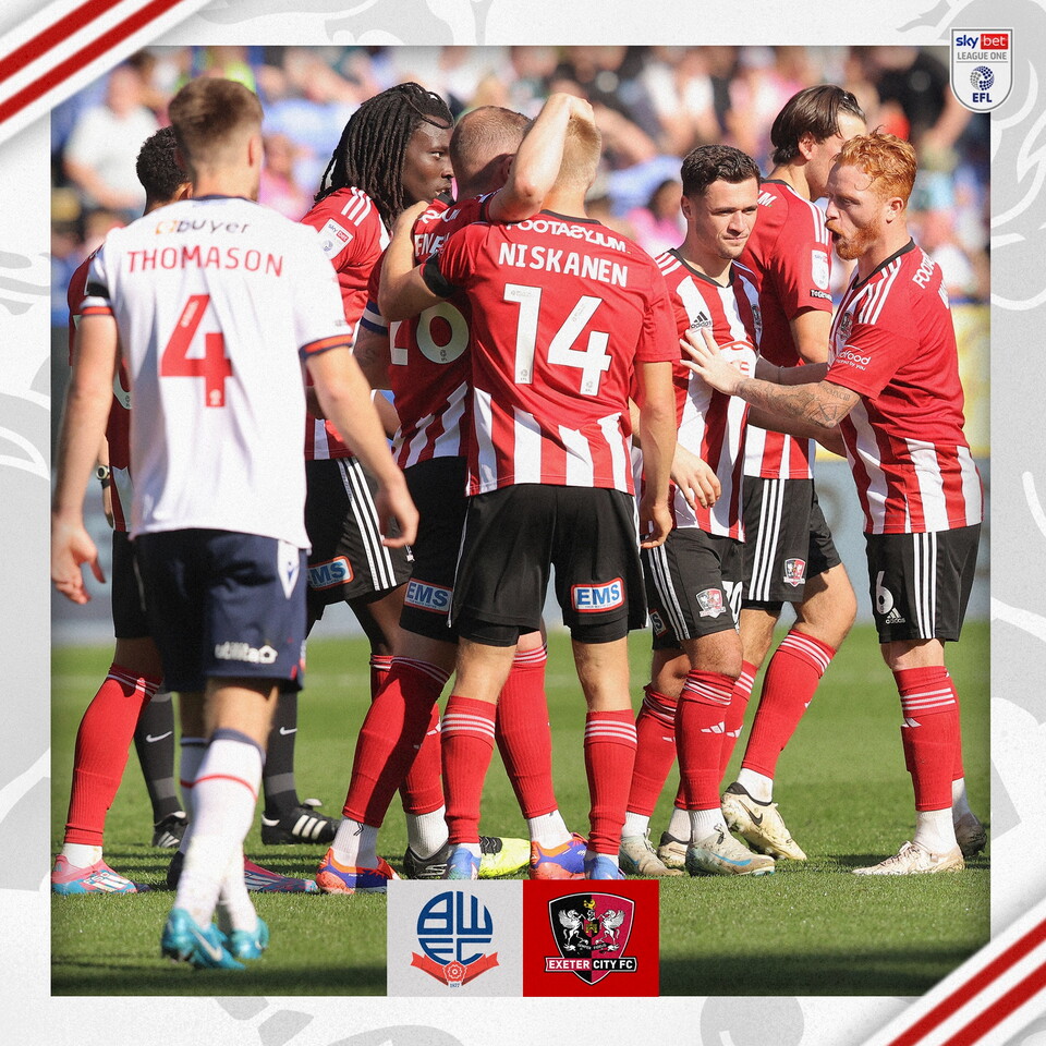A group of Exeter City players celebrating the second goal. You can see Woods, Crama, Aitchison, Niskanen, Sweeney, Yfeko, and a Bolton player walking just behind them.