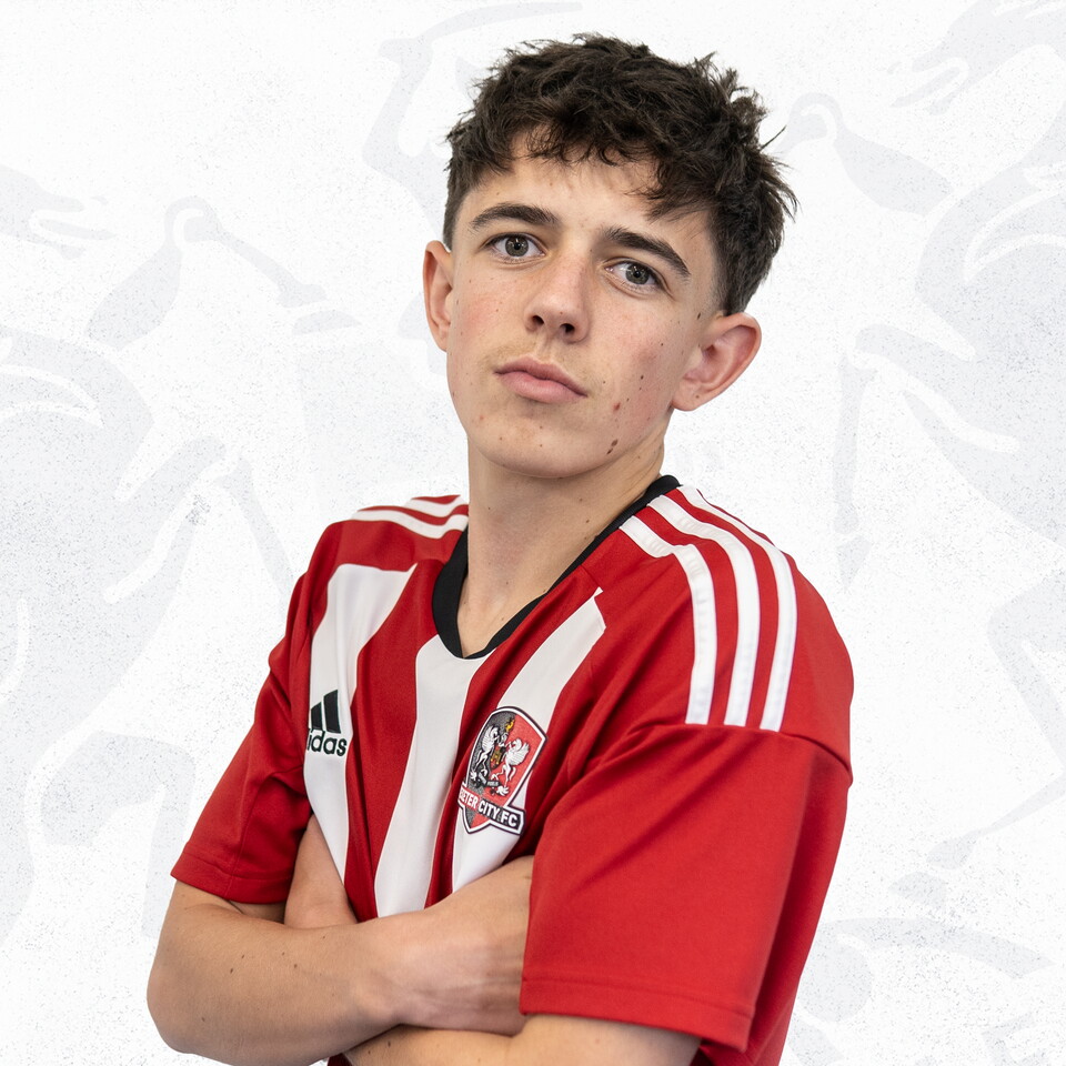 Aidan Bown profile picture. He's crossing his arms while wearing the red and white home kit, he has brown hair in a messy fringe.