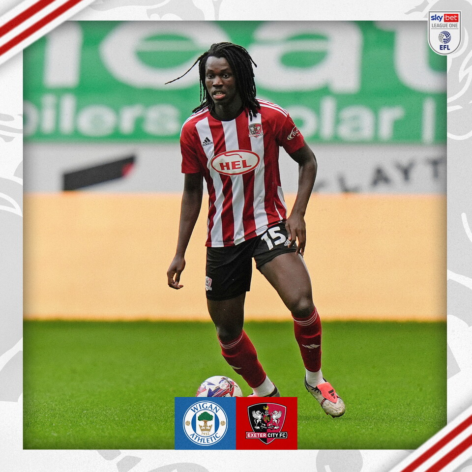 Johnly Yfeko, in his red and white home kit, on the ball looking up during the first half of Wigan v Exeter City