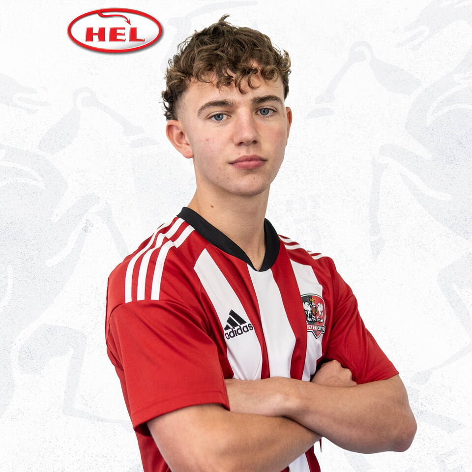 Jacca Cavendish, wearing a red and white home shirt, with his arms folded facing side on. The red and white HEL logo is in the corner of the image.