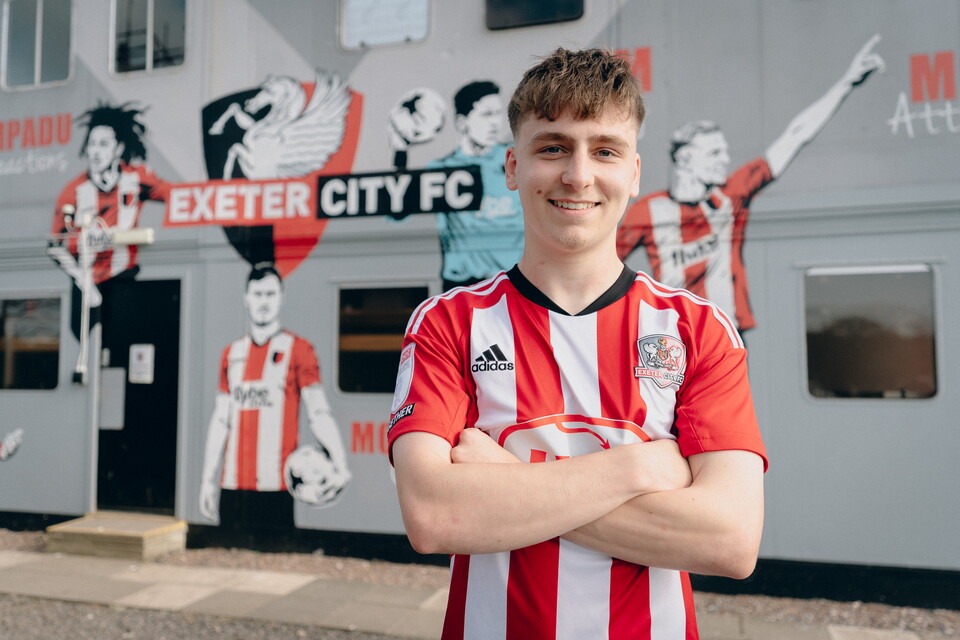 Liam Oakes with his Exeter City shirt on in front of the academy building at the Cliff Hill