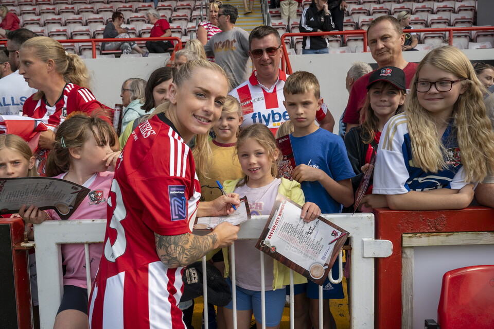 Image of amber Pollock signing autographs after an Exeter City women's match