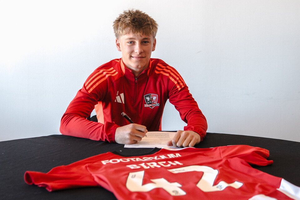 George Birch Signing his first professional contract on a table with the Birch 42 shirt laid out in front of him