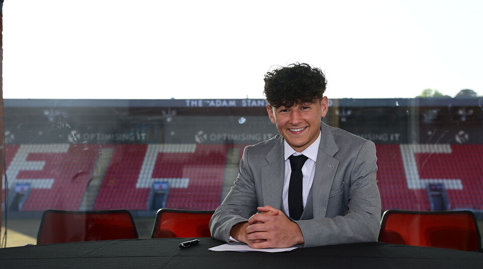 Image of Louie Cayless signing his scholarship