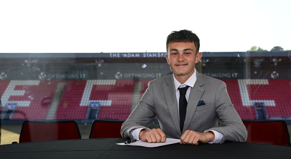 Image of Percy Baker signing his under-18 scholarship