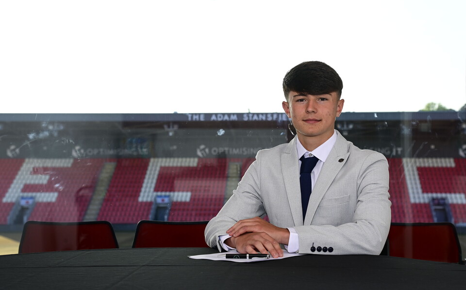 Image of Logan Aston signing his scholarship