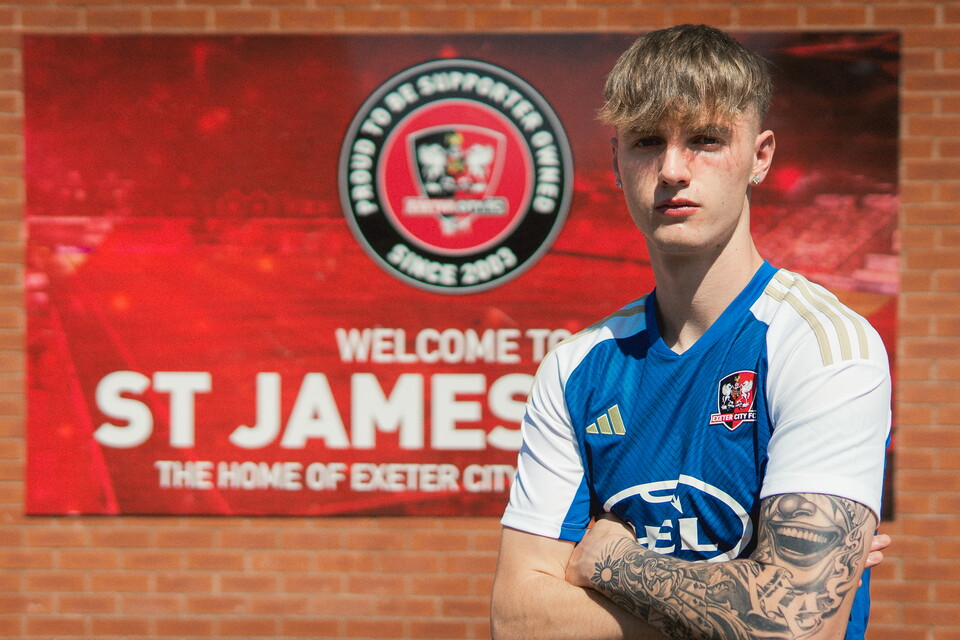 Image of Kieran Wilson in a blue city top with a SJP backdrop behind him