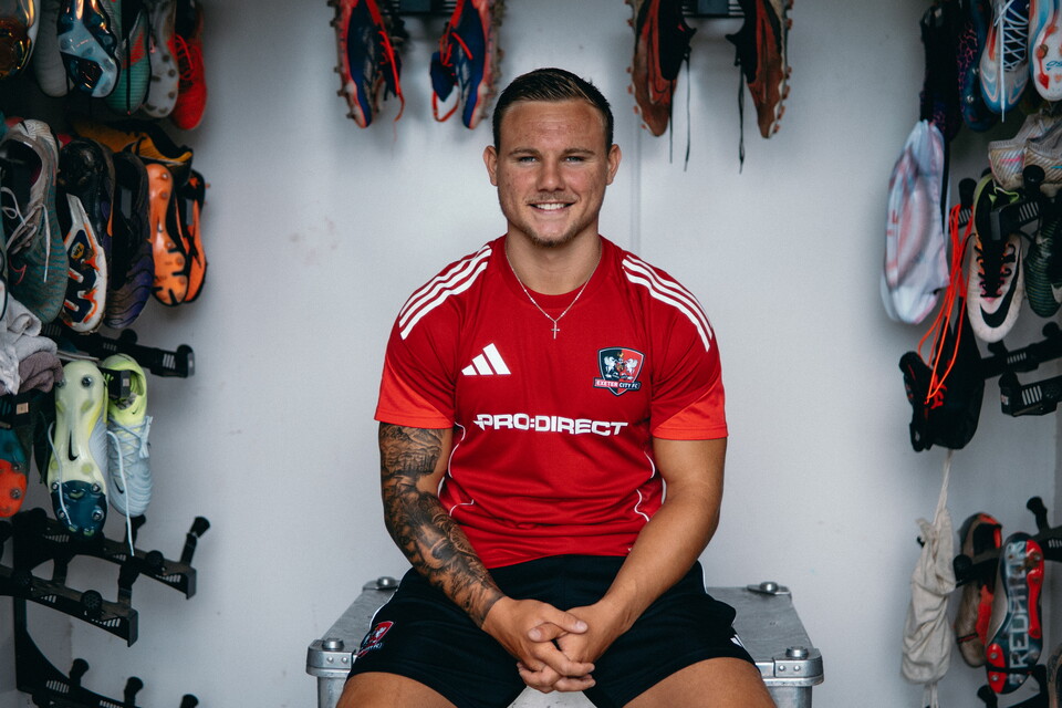 Image of Jayden Wareham, sat smiling in the boot room at the Cliff Hill Training Ground