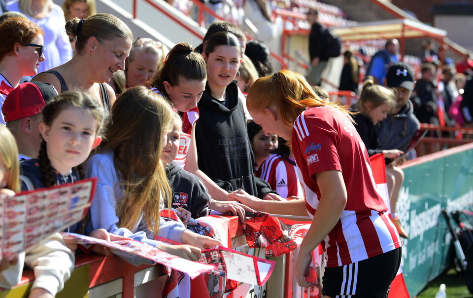 Jess Sandland signs a poster for Exeter City Women