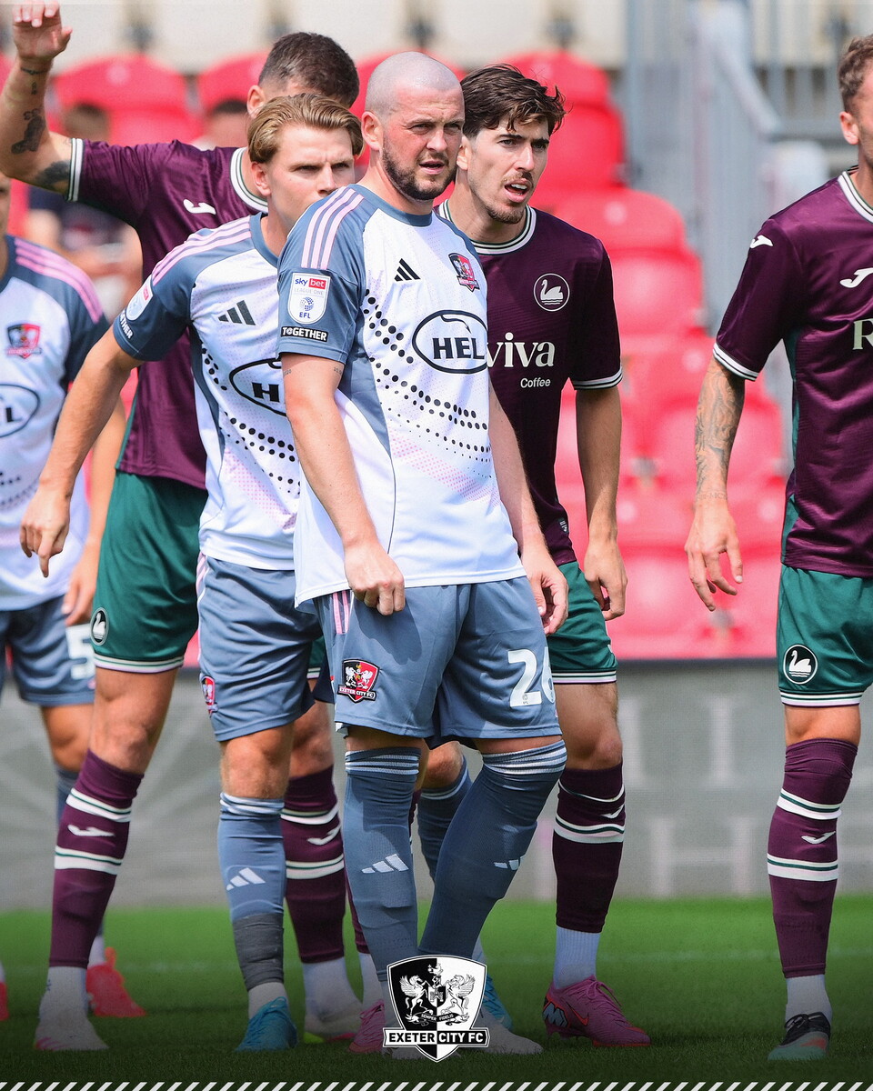 Image of Pierce Sweeney, wearing his new off-white third kit, walking on the pitch at SJP during the match between Exeter and Swansea