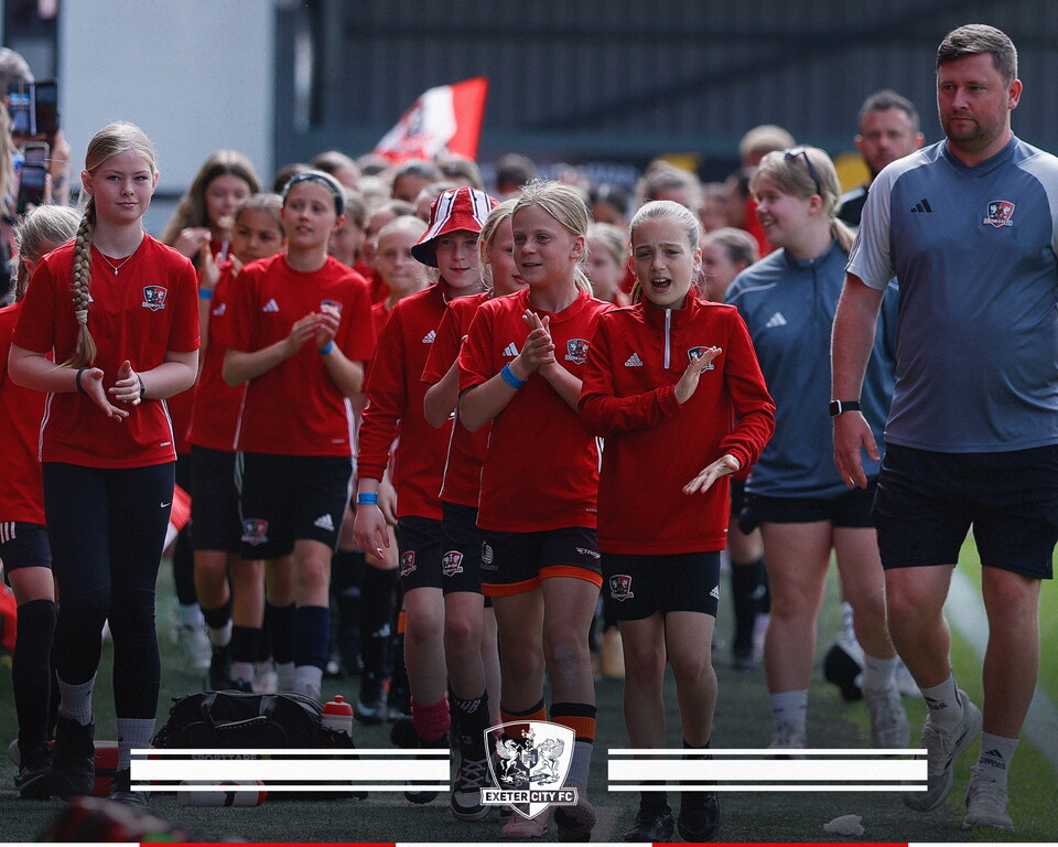 Players and coaches from the Girls' Development Pathway on the pitch at St James Park