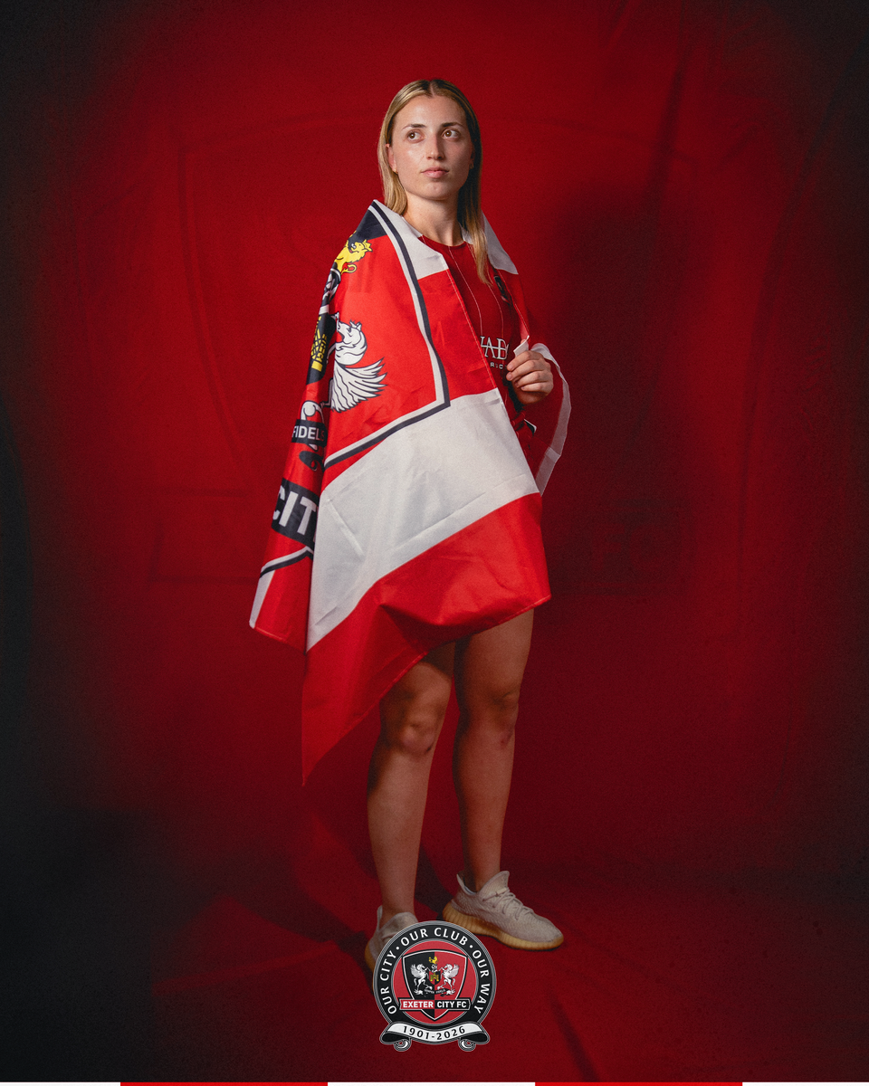 Image of Giota Papaioannou standing with a city flag draped on her