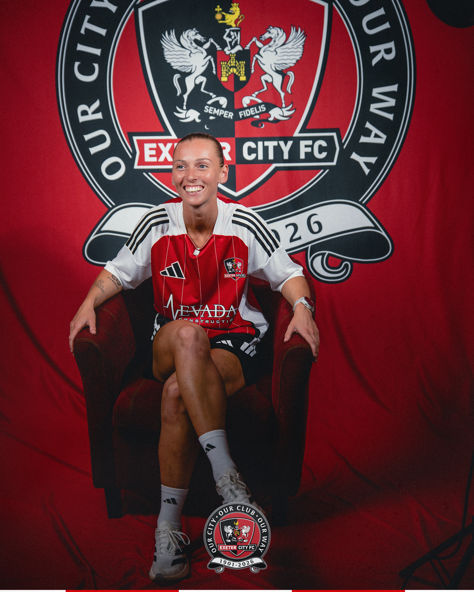 Image of Charlotte Whitmore sat on a sofa while signing for City