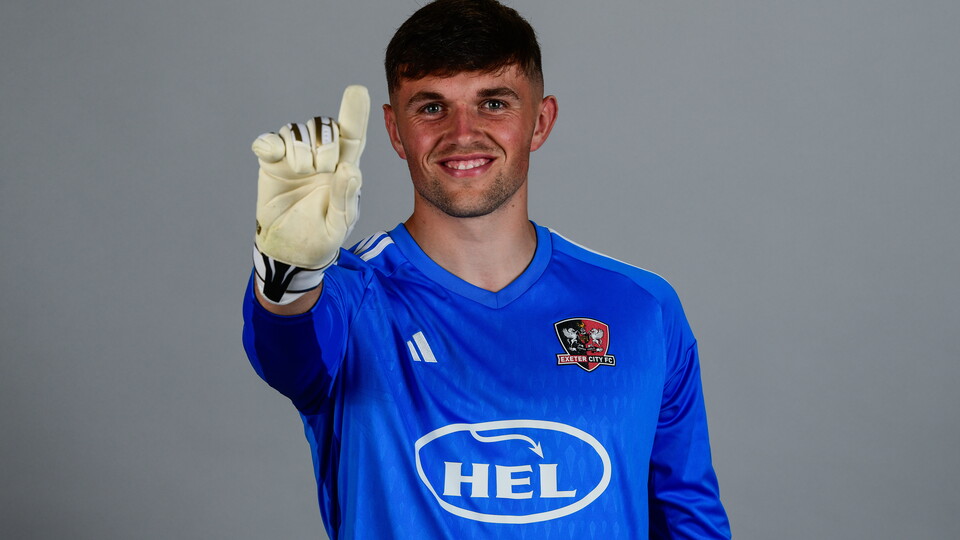 Exeter City goalkeeper Harry Lee points his glove to the sky