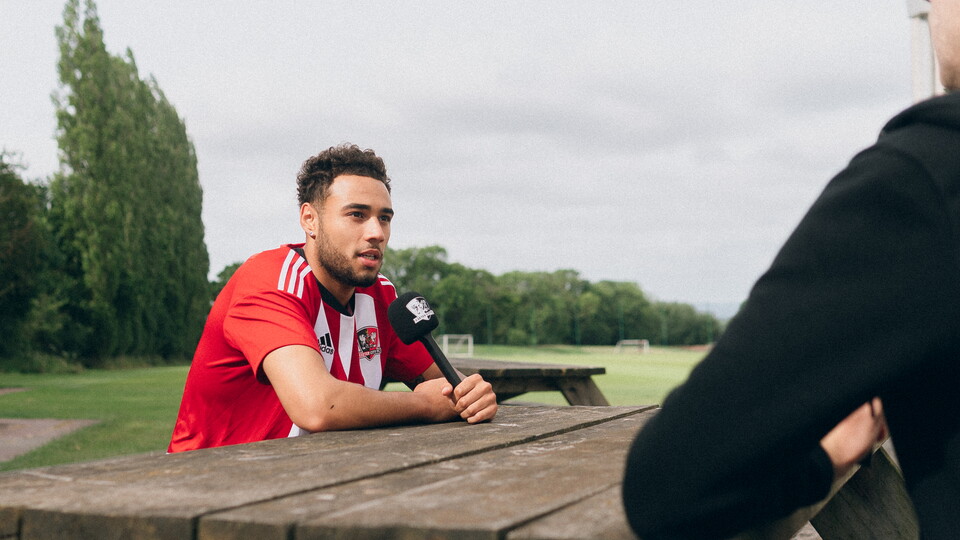 Jay Bird being interviewed, holding an ECFC branded microphone
