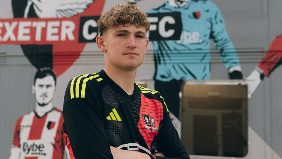 Frankie Phillips standing in front of the ECFC Academy building
